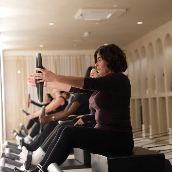 Participant practising a seated Pilates ring exercise at Forma studio.